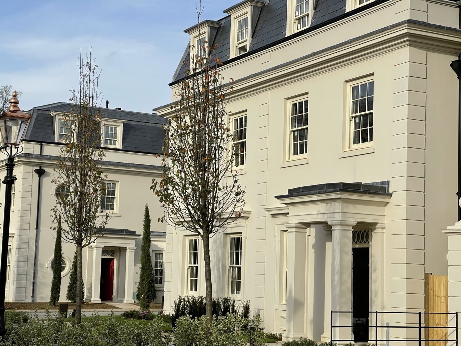 Rendered new-build houses with lightweight architectural mouldings, including quoins, window surrounds, cornices and door canopies